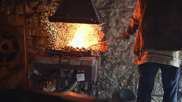 A Viking blacksmith with a white beard and braided hair works intently at a forge, hammering glowing metal on an anvil, with flames flickering in the background of a stone workshop cinematic slow