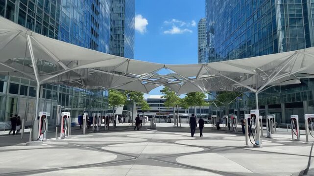 Corporate courtyard with EV chargers beneath tensile canopies