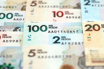 Colombian pesos money bills banknotes lies in big pile on table close up. Concept of finances and business in Colombia
