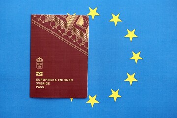 Swedish biometrical passport on European Union flag background. Concept of citizenship of Sweden