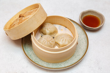 Xiao Long Bao au porc – brioche de Shanghai servie dans un panier à vapeur avec sauce