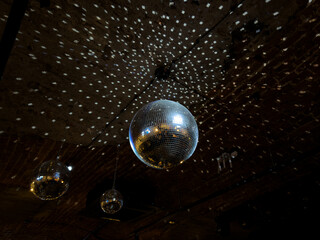 Disco balls on ceiling of nightclub. Concept for dancing and relaxation in nightclub. Silver dance ball with adjacent sections for beautiful lighting of dance floor