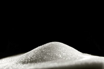 Sparkly hourglass sand on black background. Minimalist low key photo for concepts of time, travel to the desert color of 2026 year cloud white