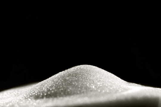 Sparkly hourglass sand on black background. Minimalist low key photo for concepts of time, travel to the desert color of 2026 year cloud white - Powered by Adobe