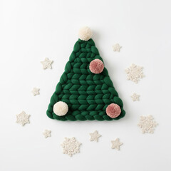 Stylized minimalist image of a handmade knitted Christmas tree with soft pastel pom-poms. Clean, elegant winter craft design.