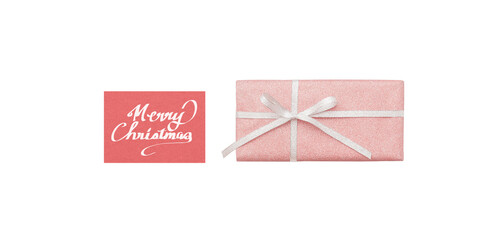 A pale pink gift box and a red Christmas card with white handwritten text, seen from above