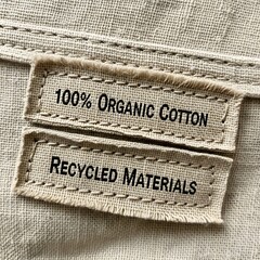Close up of a clothing tag indicating 100 organic cotton and recycled materials
