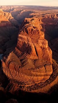 Sweeping aerial drone shot tracing the winding, deep curves of a dry canyon wall revealing geological stratification and abstract shapes wide, desert, aerial