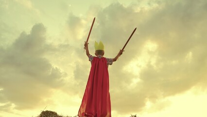 child superhero game sunset. red cape childish fantasy. countryside. golden crown head kid. achieve victory success. schoolboy plays sword. happy child superman red raincoat nature. concept happy