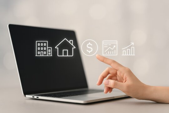User interacting with financial icons on a laptop screen, representing real estate investment, financial growth, and data-driven decisions in a digital economy.