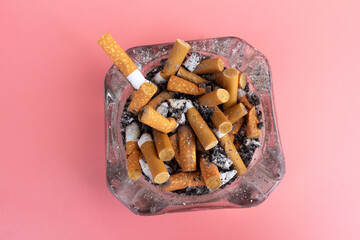 cigarette butts torn on pink background ashtray