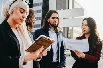 Diverse business team have meeting, discussing a project outside office buildings – Teamwork, leadership and corporate strategy concept