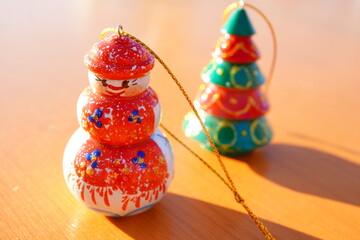 木製の可愛い雪だるまオーナメントを明るい光の中で撮影。手作り感のある温かいデザインが魅力。季節イベント、クリスマス装飾、ギフト、商品紹介に使える冬の素材。