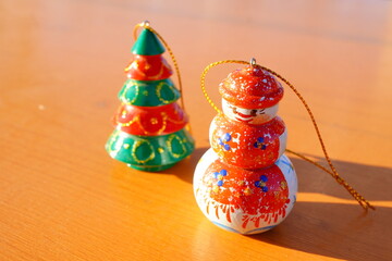 雪だるまとクリスマスツリーの木製オーナメントが並んだ温かみのある冬の雑貨写真。季節感、イベント、販売紹介、ディスプレイイメージとして幅広く利用できる素材。