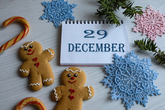 December 29th calendar: the number 29, the month's name in English, gingerbread cookies, and delicate snowflakes nearby