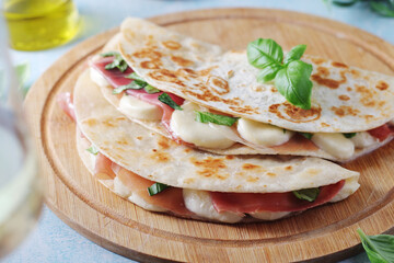 Traditional Italian dish Piadina romagnola - flat bread with mozarella and proscuitto