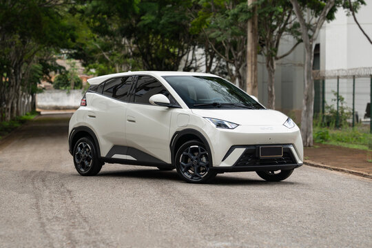 White BYD Dolphin Mini front three quarter view, Electric city car on street