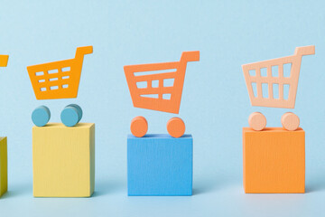 Colorful shopping cart icons on blocks against a light blue background. a row of shopping cart symbols, each on a different colored block, creating a playful design.