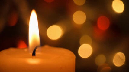 Bright candle flame burning warmly against festive bokeh lights. - Powered by Adobe