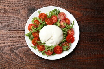 Delicious burrata cheese with arugula and tomatoes on wooden table, top view
