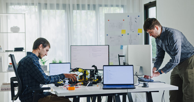 Team of male developers work code control robotics system and software automation project write prompt AI data bot at office. Artificial intelligence, collaboration, robotic, debugging, machine learn.