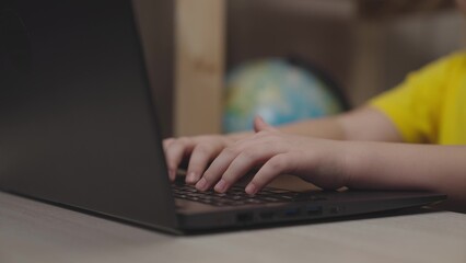 children hands typing keyboard. close-up. boy studying remotely at home. kid classes school computer class. child son writes with keys while working computer. children time to learn getting knowledge.