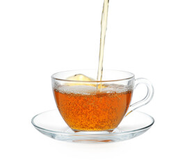 Pouring hot tea in glass cup on white background