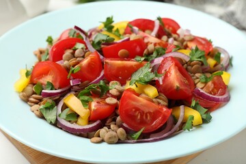 Delicious salad with lentils and vegetables on white table, closeup