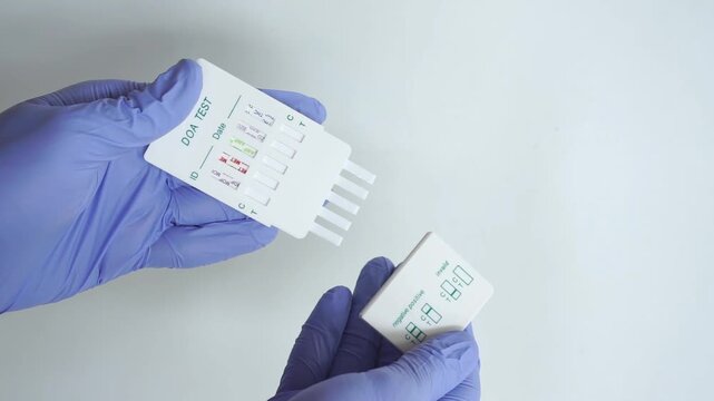Holds a drug test kit to find out five types of drugs in the body's womb through urine. wearing medical gloves and holding a drug test kit, isolated on white