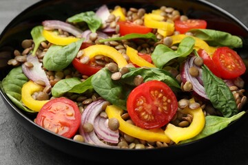 Tasty salad with lentils and vegetables on grey table, closeup