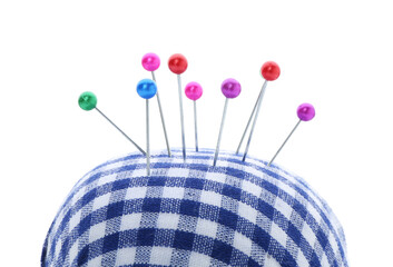 Checkered pincushion with pins on white background. Sewing accessory