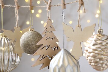 Fototapeta premium Beautiful Christmas decor hanging on string against blurred lights, closeup