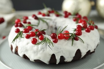 Tasty Christmas cake with cranberries and rosemary on table, closeup