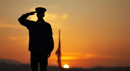 Silhouette of soldier saluting at sunset with american flag in the background