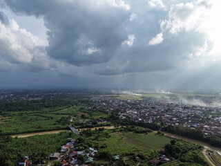 Aerial view of a city under dramatic storm clouds and darkening sky