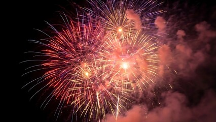 Fototapeta premium Vibrant Red Yellow and Purple Fireworks Exploding in Night Sky