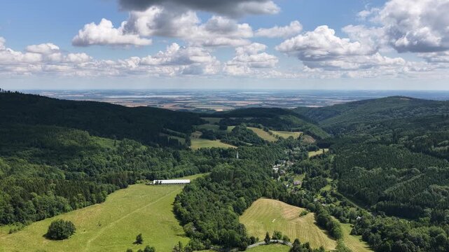 Aerial drone summer panoramic view of Ladek Zdroj town nestled in scenic Klodzko Valley Poland, surrounded by lush greenery and rolling hills of the Golden Mountains