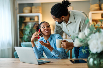 Portrait of a young black man and woman, a young couple, or businessman and businesswoman, using laptop in home office, business and teamwork, cooperation and brainstorming concept