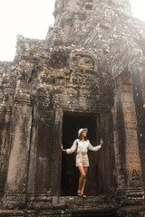 Young Tourist Exploring Bayon Temple Ancient Stone Faces In Cambodia