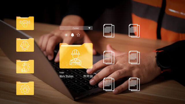 Construction engineer using laptop with virtual data folder interface. Concept of digital project management, industrial document storage, site safety reporting, and cloud file organization.