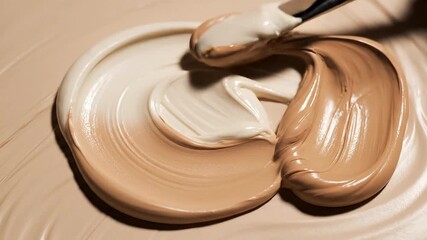 Creamy foundation being smoothed with a brush creates a flawless base, perfect for beauty tutorials and makeup artistry demonstrations