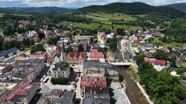 Aerial drone summer panoramic view of Ladek Zdroj town nestled in scenic Klodzko Valley Poland, surrounded by lush greenery and rolling hills of the Golden Mountains