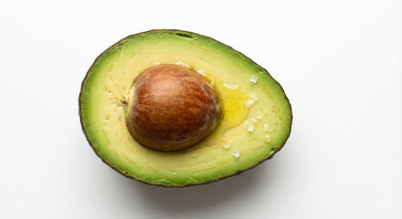 Freshly cut ripe avocado half with pit, drizzled with olive oil and sea salt flakes on a clean white background, showcasing healthy eating and gourmet simplicity.