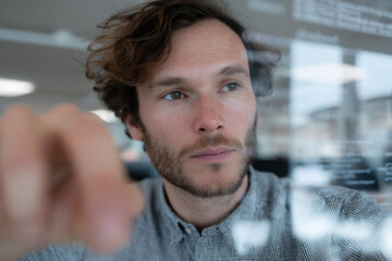 Developer coding on a transparent touchscreen.