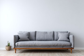 Contemporary gray fabric sofa rests against a light wall above wooden flooring