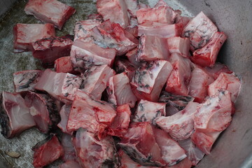 Raw chopped rohu fish pieces in a metal bowl ready for cooking