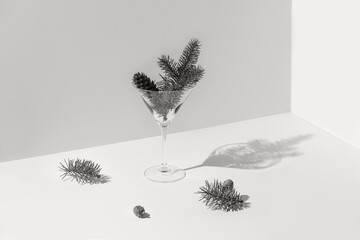Winter holiday composition  made of martini glass with spruce branch and cones. Minimal style. Christmas and new year concept. Color of the year 2026 inspired