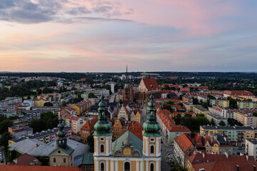 Obraz premium Aerial drone sunset view of Nysa historic town square and church in Opole Poland, golden hour on Renaissance baroque architecture, cobblestone market, cathedral tower, red rooftops