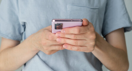 A woman is holding a pink cell phone in her hand