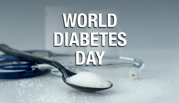A spoon with a container of sugar on it. The spoon is on a table with a white background. The image is titled World Diabetes Day